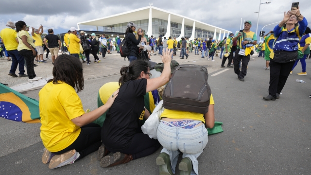Protesters, supporters of Brazil's former President Jair Bolsonaro, kneel to pray as they storm the Planalto Palace in Brasilia, Brazil, Sunday, Jan. 8, 2023. Planalto is the official workplace of the president of Brazil. (AP Photo/Eraldo Peres)