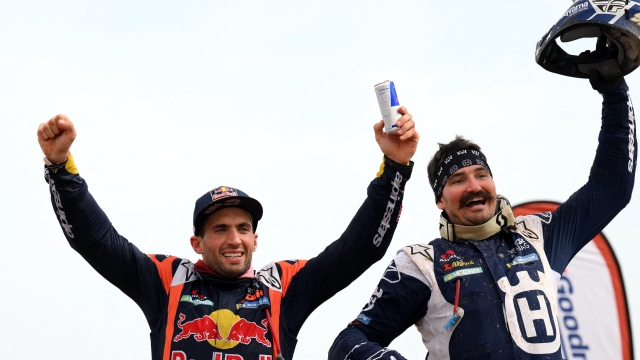 Argentina's biker Kevin Benavides (L) celebrates his victory next to US' biker Skyler Howes after winning the Dakar Rally 2023, at the end of the last stage between between Al-Hofuf and Dammam, in Saudi Arabia, on January 15, 2023. - Benavides won the Dakar Rally motorbike title for a second time as the historic endurance race came to an end on Sunday in Dammam, Saudi Arabia. The 34-year-old 2021 champion edged out Australian Toby Price by 43 seconds with Skyler Howes of the United States finishing third according to race organisers Amaury Sport Organisation (ASO). (Photo by FRANCK FIFE / AFP)
