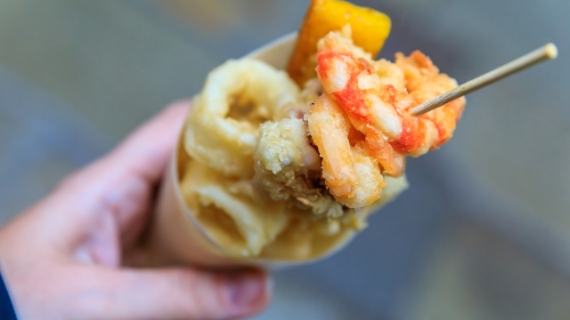 Italian street food in Venice - fritto misto (mix of fried fish, calamari or squid and shrimp) in a cone on the go