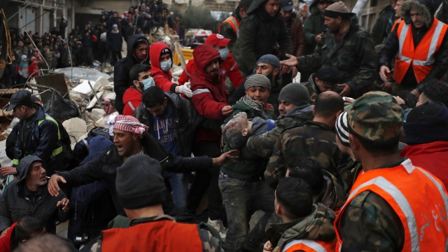 Civil defense workers and security forces carry an earthquake victim as they search through the wreckage of collapsed buildings in Hama, Syria, Monday, Feb. 6, 2023. A powerful earthquake has caused significant damage in southeast Turkey and Syria and many casualties are feared. Damage was reported across several Turkish provinces, and rescue teams were being sent from around the country. (AP Photo/Omar Sanadiki)