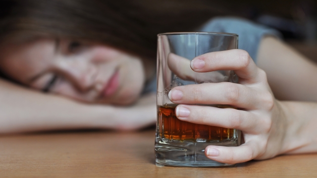 Drunk female with a glass of whiskey