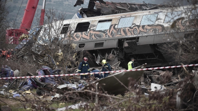 Police and emergency crew search the debris of a crushed wagon after a train accident in the Tempi Valley near Larisa, Greece, March 1, 2023. - At least 29 people were killed and another 85 injured after a collision between two trains caused a derailment near the Greek city of Larissa late Tuesday night, February 28, 2023, authorities said. A fire services spokesman confirmed that three carriages skipped the tracks just before midnight after the trains -- one for freight and the other carrying 350 passengers - collided about halfway along the route between Athens and Thessaloniki. (Photo by Sakis MITROLIDIS / AFP)