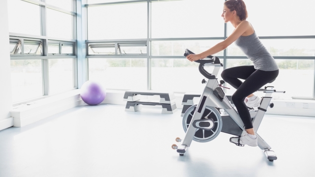 Woman riding an exercise bike in gym