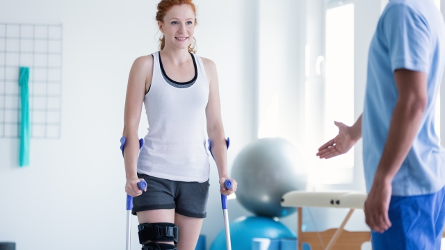 Woman walking with crutches during physiotherapy