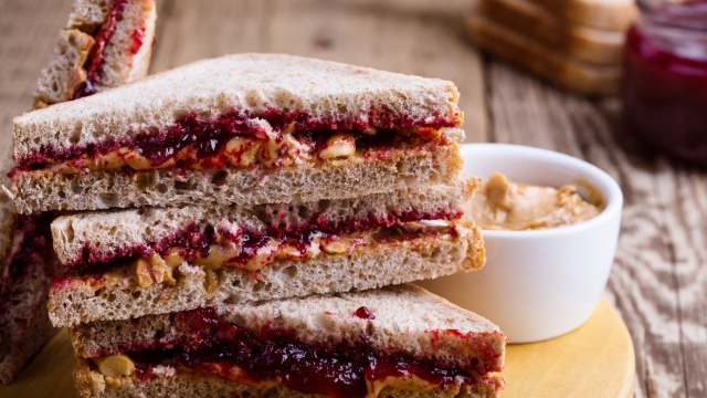 Peanut butter and jelly sandwich with whole wheat bread on rustic wooden table