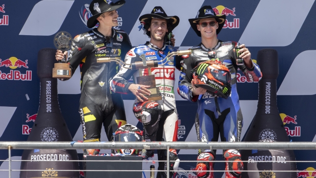 Race winner Alex Rins, center, of Spain, celebrates with second-place Luca Marini, left, of Italy, and third-place Fabio Quartararo, right, of France, after the MotoGP Grand Prix of the Americas motorcycle race at the Circuit of the Americas, Sunday, April 16, 2023, in Austin, Texas. (AP Photo/Darren Abate)