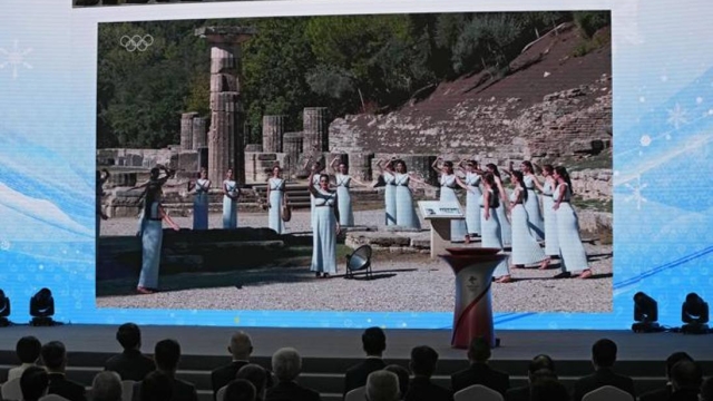 Chinese officials and invited guests watch a video showing the lighting of the Olympic flam ceremony at Ancient Olympia site, birthplace of the ancient Olympics in southwestern Greece, during a welcome ceremony for the Frame of Olympic Winter Games Beijing 2022 held at the Olympic Tower in Beijing, Wednesday, Oct. 20, 2021. A welcome ceremony for the Olympic flame was held in Beijing on Wednesday morning after it arrived at the Chinese capital from Greece. While the flame will be put on display over the next few months, organizers said a three-day torch relay is scheduled starting Feb. 2 with around 1200 torchbearers in Beijing, Yanqing and Zhangjiakou. (AP Photo/Andy Wong)