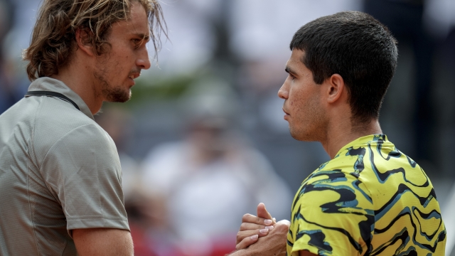 Alexander Zverev, of Germany, left, shakes hands with Carlos Alcaraz, of Spain, at the ne of the match at the Madrid Open tennis tournament in Madrid, Spain, Tuesday, May 2, 2023. (AP Photo/Manu Fernandez)