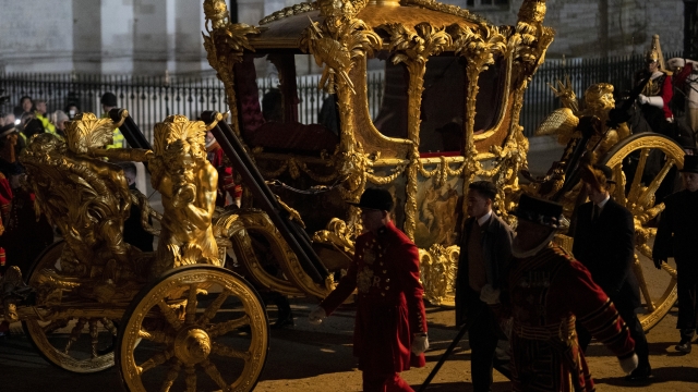 The Gold State Coach is led in a procession as it leaves Westminster Abbey in central London, early Wednesday, May 3, 2023, during a rehearsal for the coronation of King Charles III which will take place at Westminster Abbey on May 6. (AP Photo/Vadim Ghirda)