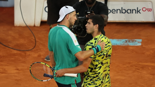 Spain's Carlos Alcaraz (R) greets Germany's Jan-Lennard Struff after winning their 2023 ATP Tour Madrid Open tennis tournament singles final match at Caja Magica in Madrid on May 7, 2023. (Photo by Thomas COEX / AFP)