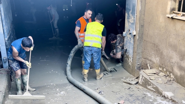 Alcuni volontari svuotano un garage dal fango con laiuto dei mezzi della Protezione Civile, Faenza, 9 maggio 2023. ANSA/FRANCESCO ARRIGONI
