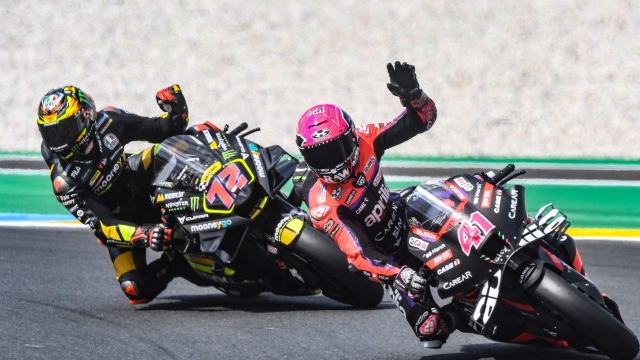 Aprilia Racing Team's Spanish rider Aleix Espargaro (R) waves  next Mooney VR46 Racing Team's Italian rider Marco Bezzecchi (L) after the 2nd free practice session ahead of the French MotoGP Grand Prix race of the French motorcycling Grand Prix, in Le Mans, northwestern France, on May 12, 2023. (Photo by JEAN-FRANCOIS MONIER / AFP)