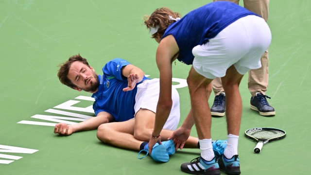 TOPSHOT - Daniil Medvedev of Russia reacts as Alexander Zverev of Germany touches his foot after Medvedev fell during second set action in their fourth round tennis match at the 2023 ATP Indian Wells Masters on March 14, 2023 in Indian Wells, California. (Photo by Frederic J. BROWN / AFP)