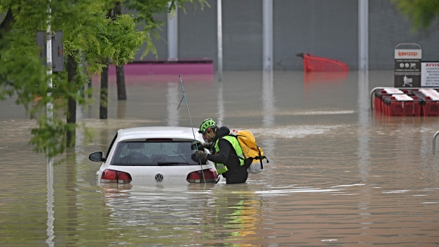 A speleological alpine rescuer looks in a car for missing persons near a supermarket in a flooded area in Cesena on May 17, 2023. Heavy rains have caused major floodings in central Italy, where trains were stopped and schools were closed in many towns while people were asked to leave the ground floors of their homes and to avoid going out. Five people have died after the floodings across Italy's northern Emilia Romagna region, a local official said. (Photo by Alessandro SERRANO / AFP)