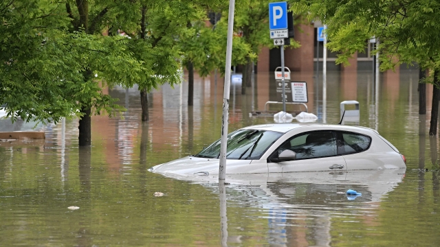 A picture taken in Cesena on May 17, 2023 shows a car in a flooded supermarket area after heavy rains have caused major floodings in central Italy, where trains were stopped and schools were closed in many towns while people were asked to leave the ground floors of their homes and to avoid going out. (Photo by Alessandro SERRANO / AFP)