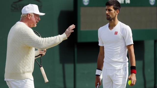 FILE - Novak Djokovic, of Serbia, right, speaks with his coach Boris Becker before resuming his men's singles match against Sam Querrey of the U.S on day six of the Wimbledon Tennis Championships in London, July 2, 2016. Tennis great Boris Becker has been sentenced to 2 1/2 years in prison for illicitly transferring large amounts of money and hiding assets after he was declared bankrupt. The three-time Wimbledon champion was convicted earlier this month on four charges under the Insolvency Act and had faced a maximum sentence of seven years in prison. (AP Photo/Ben Curtis, File)