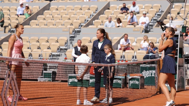Ukraine's Marta Kostyuk (R) and Belarus' Aryna Sabalenka (L) attend the toss prior to their women's singles match on day one of the Roland-Garros Open tennis tournament at the Court Philippe-Chatrier in Paris on May 28, 2022. (Photo by Thomas SAMSON / AFP)