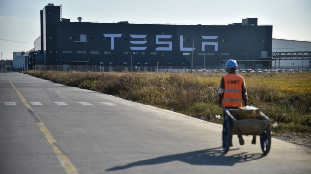 (FILES) A worker walks on a road next to the new Tesla factory in Shanghai on November 8, 2019. Tesla's Elon Musk met China's foreign minister Qin Gang in Beijing on May 30, 2023, the Chinese ministry said in a statement. (Photo by HECTOR RETAMAL / AFP)