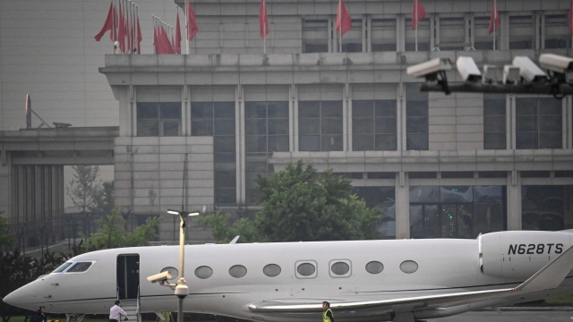 Tesla Chief Executive Officer Elon Musk (in white) boards his private jet before departing from Beijing Capital International Airport on May 31, 2023. Musk praised China's "vitality and promise" on May 31, Beijing said, during a trip to the Chinese capital in which he has met multiple government officials and reportedly declared he will expand his business there. (Photo by Jade Gao / AFP)
