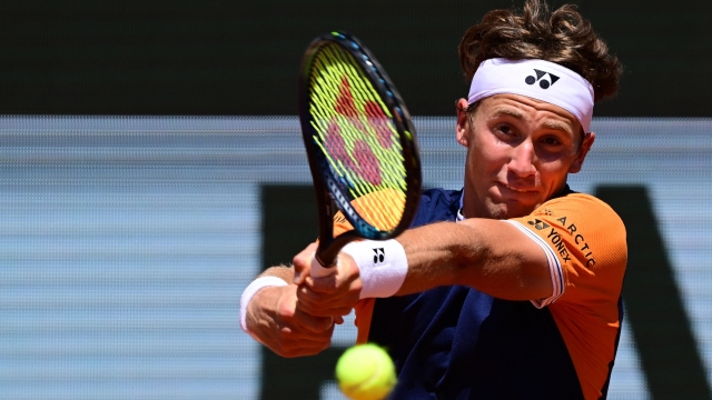 TOPSHOT - Norway's Casper Ruud plays a backhand return to Italy's Giulio Zeppieri during their men's singles match on day five of the Roland-Garros Open tennis tournament at the Court Philippe-Chatrier in Paris on June 1, 2023. (Photo by Emmanuel DUNAND / AFP)