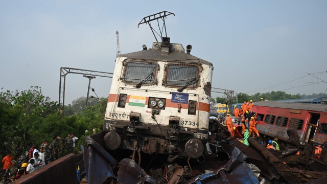 Rescue workers and military personnel gather around damaged carriages at the accident site of a three-train collision near Balasore, about 200 km (125 miles) from the state capital Bhubaneswar in the eastern state of Odisha, on June 3, 2023. At least 288 people were killed and more than 850 injured in a horrific three-train collision in India, officials said on June 3, the country's deadliest rail accident in more than 20 years. (Photo by DIBYANGSHU SARKAR / AFP)