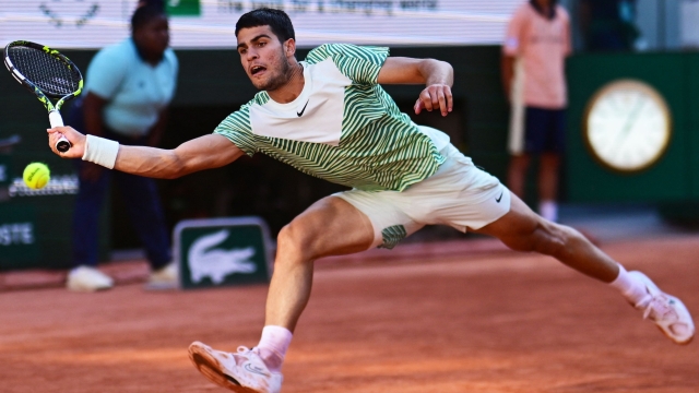 Spain's Carlos Alcaraz Garfia plays a forehand return to Italy's Lorenzo Musetti during their men's singles match on day eight of the Roland-Garros Open tennis tournament at the Court Philippe-Chatrier in Paris on June 4, 2023. (Photo by Emmanuel DUNAND / AFP)