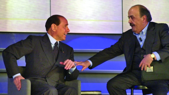 Italy's media mogul and center-right candidate Premier Silvio Berlusconi, left, and showman Maurizio Costanzo talk during the "Maurizio Costanzo"  show  in Rome, Friday, May 11, 2001, during the last hours of his electoral campaign. Berlusconi is running against center-left candidate Premier Francesco Rutelli in Italy's May 13 general elections. (AP Photo/Plinio Lepri)