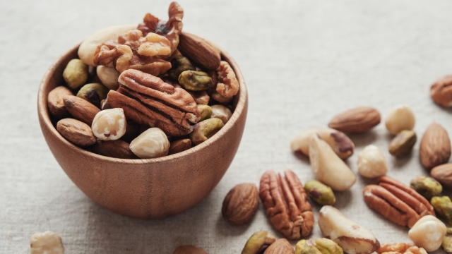 mixed nuts in wooden bowl, healthy fat and protein food and snack, ketogenic diet food