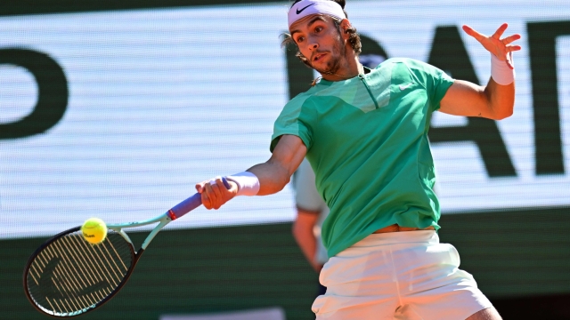 Italy's Lorenzo Musetti plays a forehand return to Spain's Carlos Alcaraz Garfia during their men's singles match on day eight of the Roland-Garros Open tennis tournament at the Court Philippe-Chatrier in Paris on June 4, 2023. (Photo by Emmanuel DUNAND / AFP)