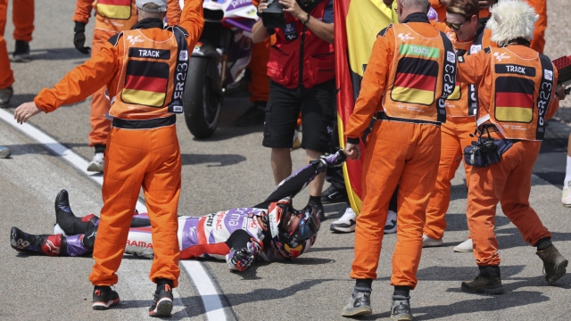 Spain's Jorge Martin, of the Prima Pramac Racing team, on the ground, celebrates with his team after winning the German Grand Prix, at the Sachsenring racing circuit, in Hohenstein-Ernstthal, Germany, Sunday, June 18, 2023. (Jan Woitas/dpa via AP)