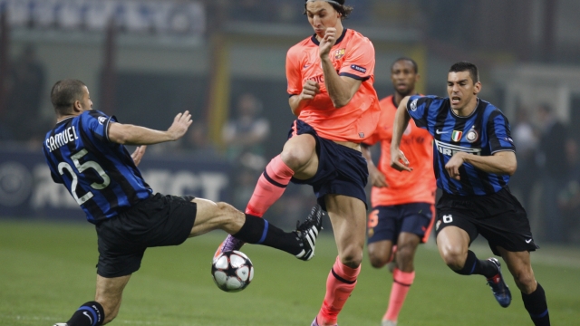 Barcelona forward Zlatan Ibrahimovic, of Sweden, center, challenges for the ball with Inter Milan Argentine defender Walter Samuel, left, as Brazilian defender Lucio arrives during a Champions League semifinal first leg soccer match between Inter Milan and Barcelona at the San Siro stadium in Milan, Italy,Tuesday, April 20, 2010. (AP Photo/Luca Bruno)