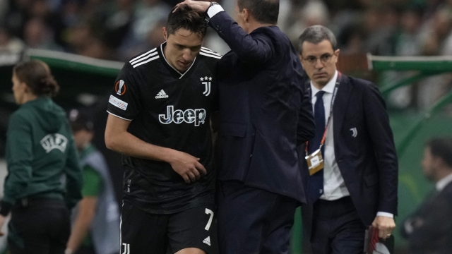 Juventus' Federico Chiesa, left, is greeted by head coach Massimiliano Allegri as he is substituted during the Europa League quarter final second leg soccer match between Sporting CP and Juventus at the Alvalade stadium in Lisbon, Thursday, April 20, 2023. (AP Photo/Armando Franca)