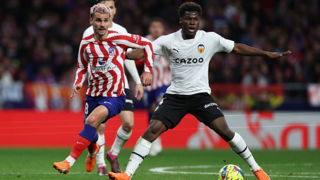 Atletico Madrid's French forward Antoine Griezmann vies with Valencia's US midfielder Yunus Musah (R) during the Spanish league football match between Club Atletico de Madrid and Valencia CF at the Wanda Metropolitano stadium in Madrid on March 18, 2023. (Photo by Pierre-Philippe Marcou / AFP)