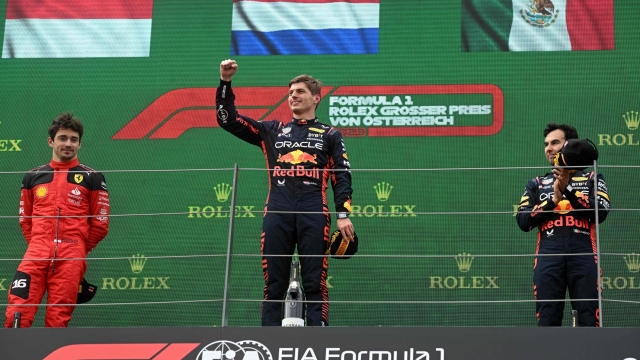 (LtoR) Second placed Ferrari's Monegasque driver Charles Leclerc, winner Red Bull Racing's Dutch driver Max Verstappen and third placed Red Bull Racing's Mexican driver Sergio Perez celebrate on the podium after the Formula One Austrian Grand Prix at the Red Bull race track in Spielberg, Austria on July 2, 2023. (Photo by VLADIMIR SIMICEK / AFP)