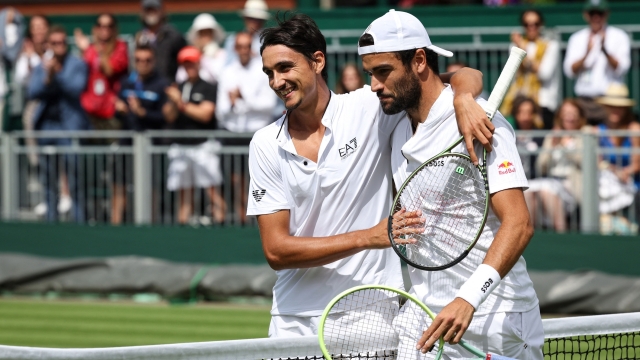 Italy's Matteo Berrettini (R) hugs Italy's Lorenzo Sonego after winning their men's singles tennis match on the fourth day of the 2023 Wimbledon Championships at The All England Tennis Club in Wimbledon, southwest London, on July 6, 2023. (Photo by Adrian DENNIS / AFP) / RESTRICTED TO EDITORIAL USE