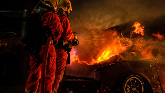 Firefighters use Twirl water fog fire extinguisher to fight with the fire flame from car accident of traffic collision in highway road. Firefighter safety disaster accident and public service concept.