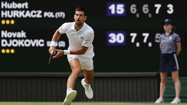 Serbia's Novak Djokovic runs to play a return against Poland's Hubert Hurkacz during their men's singles tennis match on the eighth day of the 2023 Wimbledon Championships at The All England Tennis Club in Wimbledon, southwest London, on July 10, 2023. (Photo by Adrian DENNIS / AFP) / RESTRICTED TO EDITORIAL USE