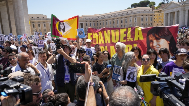 People hold pictures of missing girl Emanuela Orlandi during a sit-in in St.Peter's Square as Pope Francis recites the Angelus noon prayer, at the Vatican, Sunday, June 25, 2023. The Pope in his speech remembered the 40th anniversary of the disappearance of Emanuela Orlandi, the 15-year-old daughter of a lay employee of the Holy See, that vanished June 22, 1983, after leaving her family's Vatican City apartment to go to a music lesson in Rome. (AP Photo/Andrew Medichini)