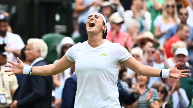 TOPSHOT - Tunisia's Ons Jabeur celebrates beating Kazakhstan's Elena Rybakina during their women's singles quarter-finals tennis match on the tenth day of the 2023 Wimbledon Championships at The All England Lawn Tennis Club in Wimbledon, southwest London, on July 12, 2023. (Photo by SEBASTIEN BOZON / AFP) / RESTRICTED TO EDITORIAL USE