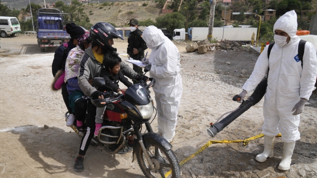 A health worker in protective gear fumigates a motorcycle near a poultry farm during a health alert due to a bird flu outbreak in Sacaba, Bolivia, Tuesday, Jan. 31, 2023. Bolivian health authorities reported on Jan. 30 that thousands of birds were culled after an outbreak of bird flu on farms, forcing the declaration of a 120-day health emergency. (AP Photo/Juan Karita)
