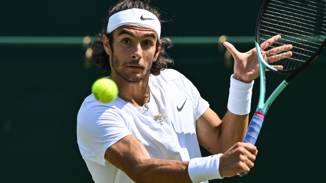 Italy's Lorenzo Musetti returns the ball to Poland's Hubert Hurkacz during their men's singles tennis match on the fifth day of the 2023 Wimbledon Championships at The All England Tennis Club in Wimbledon, southwest London, on July 7, 2023. (Photo by Glyn KIRK / AFP) / RESTRICTED TO EDITORIAL USE