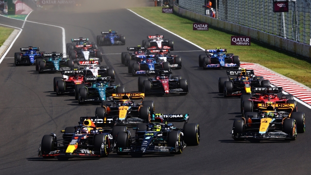 BUDAPEST, HUNGARY - JULY 23: Max Verstappen of the Netherlands driving the (1) Oracle Red Bull Racing RB19 leads Lewis Hamilton of Great Britain driving the (44) Mercedes AMG Petronas F1 Team W14 and the rest of the field into turn one at the start during the F1 Grand Prix of Hungary at Hungaroring on July 23, 2023 in Budapest, Hungary. (Photo by Mark Thompson/Getty Images)