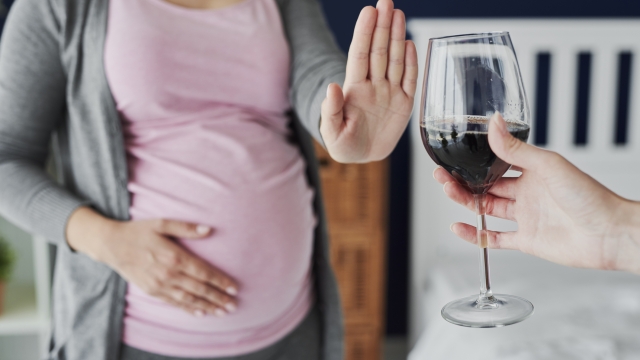 Pregnant woman refusing a glass of wine