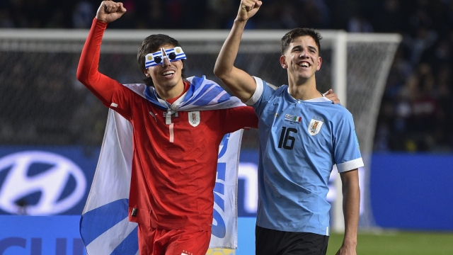 Uruguay's goalkeeper Facundo Machado, left, and Facundo Gonzalez celebrate with the trophy after winning the FIFA U-20 World Cup final soccer match against Italy at the Diego Maradona stadium in La Plata, Argentina, Sunday, June 11, 2023. (AP Photo/Gustavo Garello)