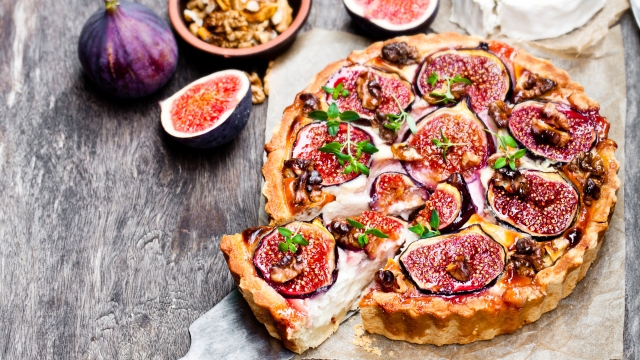 Delicious  tart with fresh figs and goat cheese on rustic wooden table