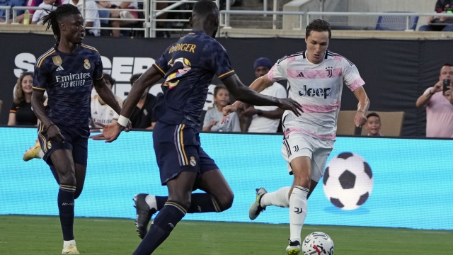 Juventus forward Federico Chiesa, right, moves the ball past Real Madrid midfielder Eduardo Camavinga, left, and defender Antonio Rudiger during the first half of a Champions Cup soccer match, Wednesday, Aug. 2, 2023, in Orlando, Fla. (AP Photo/John Raoux)
