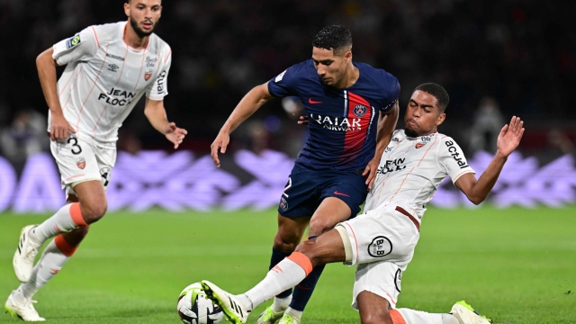 Lorient's French midfielder #21 Julien Ponceau tackles Paris Saint-Germain's Moroccan defender #02 Achraf Hakimi (C) during the French L1 football match between Paris Saint-Germain (PSG) and Lorient at the Parc des Princes Stadium in Paris on August 12, 2023. (Photo by Miguel MEDINA / AFP)