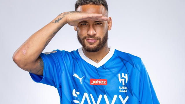 In this handout picture released by the Saudi Al-Hilal football club on August 15, 2023, Brazilian forward Neymar poses for a picture in the team's uniform in Riyadh. Brazil forward Neymar has signed for Saudi Arabia's Al-Hilal from Paris Saint-Germain, the clubs announced today, joining Cristiano Ronaldo and Karim Benzema as the latest big name lured to the oil-rich Gulf state. (Photo by Saudi Pro League / AFP)