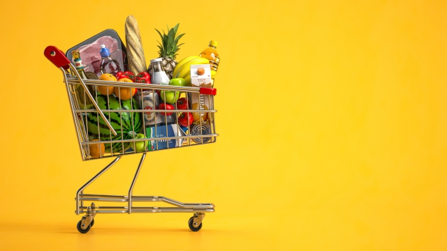 Shopping cart full of food on yellow background. Grocery and food store concept. 3d illustration