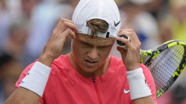 Holger Rune, of Denmark, adjusts his hat during a match Roberto Carballes Baena, of Spain, in the first round of the U.S. Open tennis championships, Monday, Aug. 28, 2023, in New York. (AP Photo/John Minchillo)